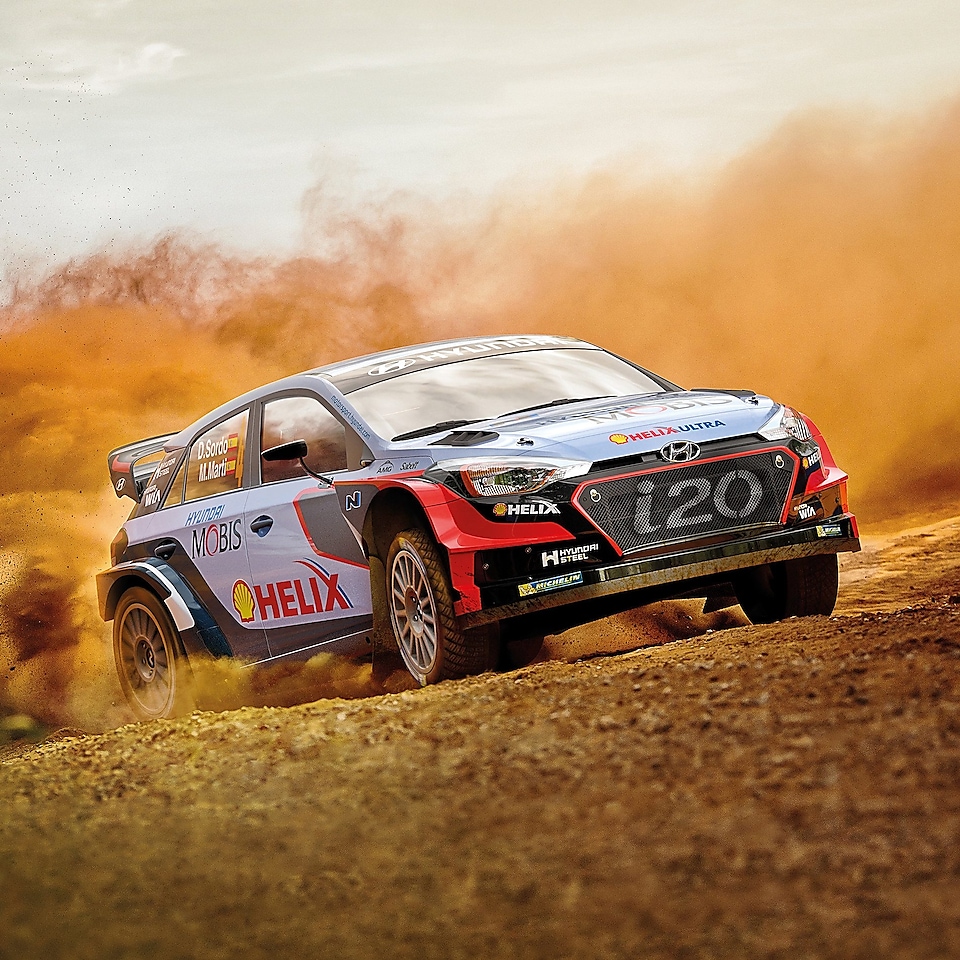A Hyundai Motorsport car kicks up a cloud of dust on a dirt race track, exemplifying the great performance of using Shell Helix Ultra in extreme environments